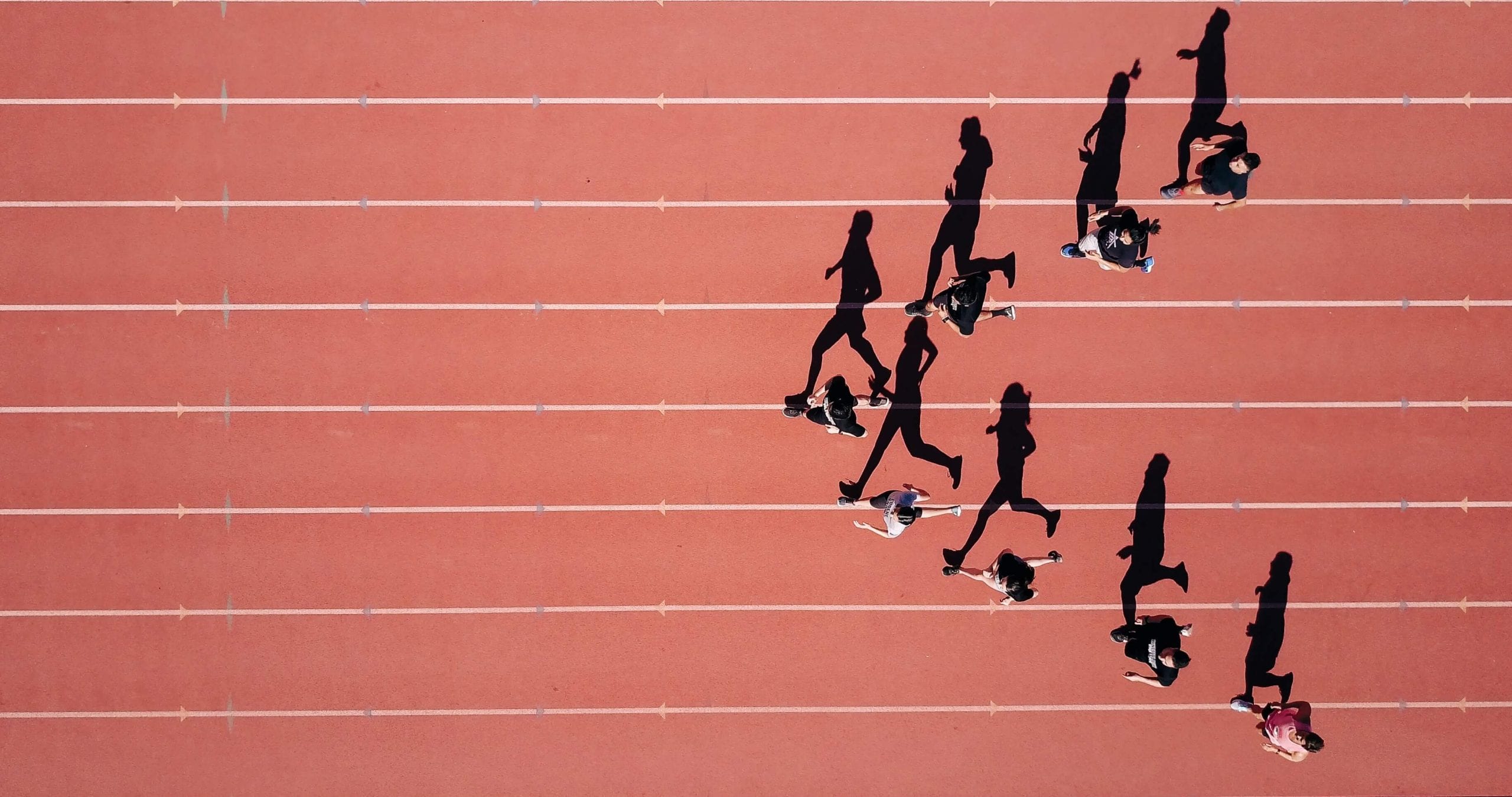 Group of people running on a track in a stadium