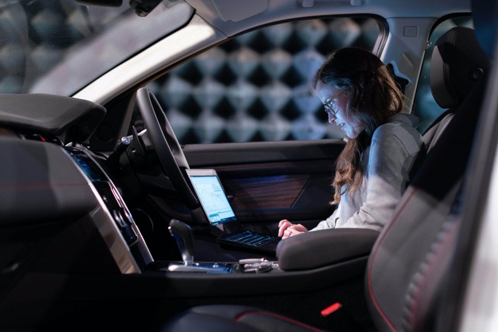 Female engineer reviewing data in a car.