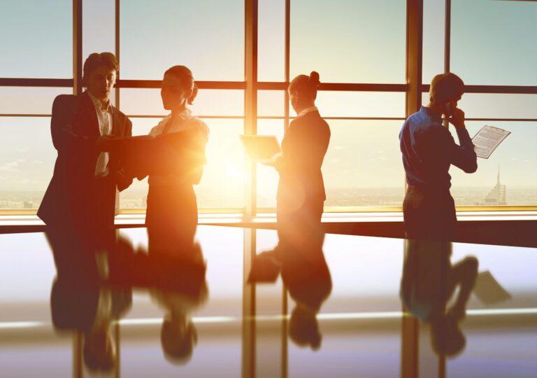 four people working by a window