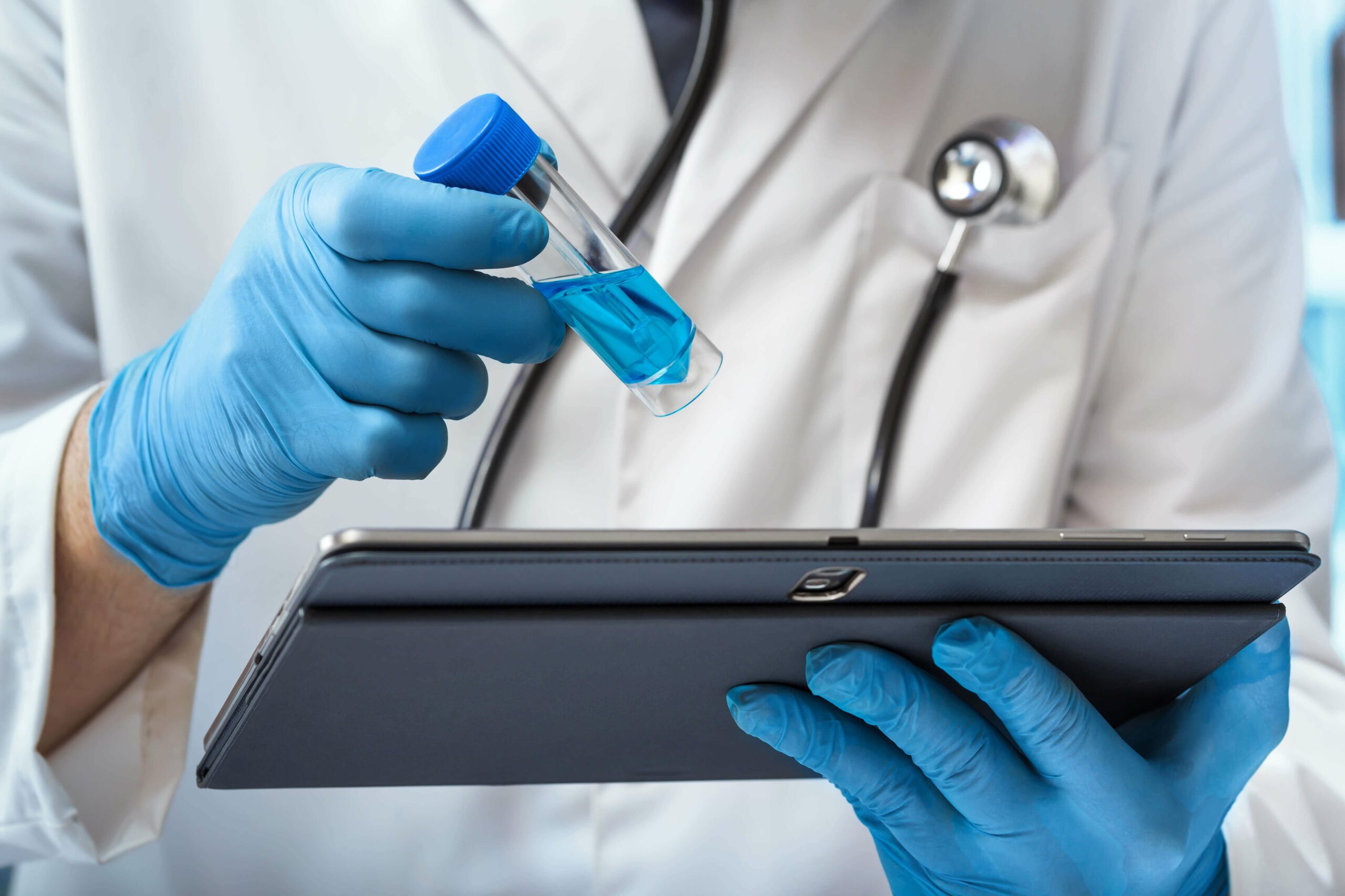 research doctor examining a test tube with a tablet